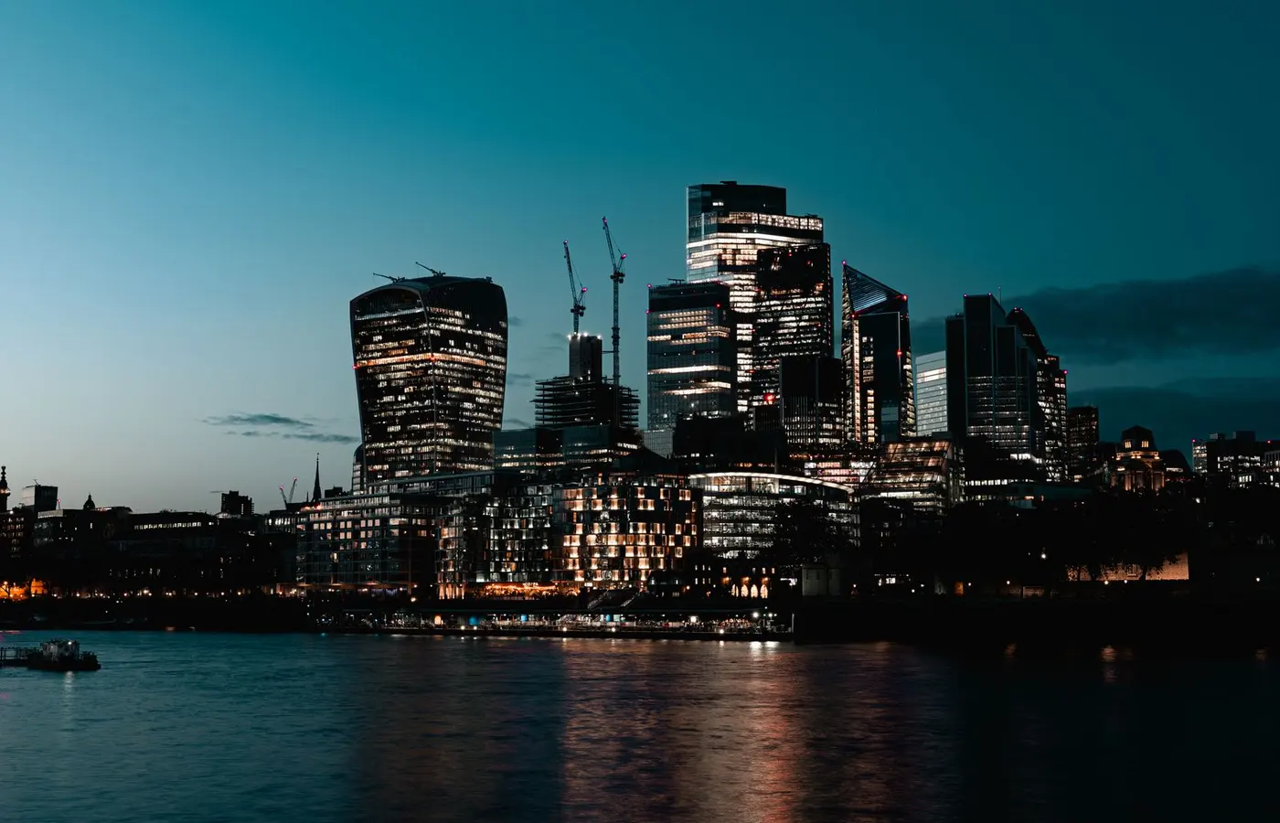 London financial district skyline at dusk reflected on the River Thames